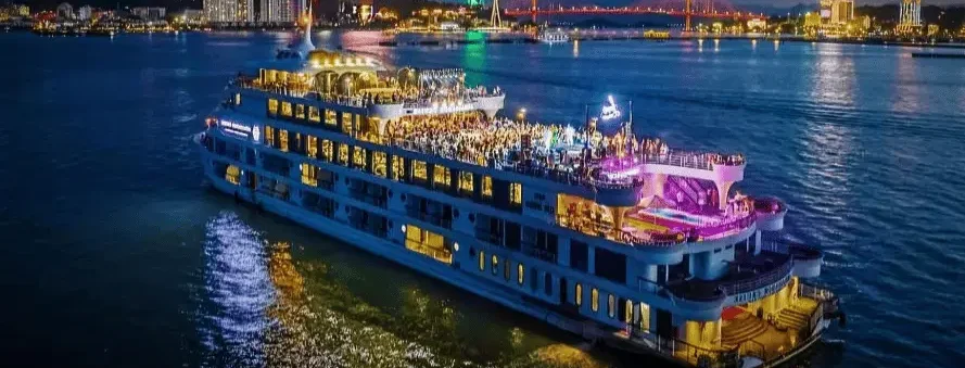 Best Dinner Cruise in Goa sailing at night with vibrant city lights and festive atmosphere — Goa Tourist Taxi