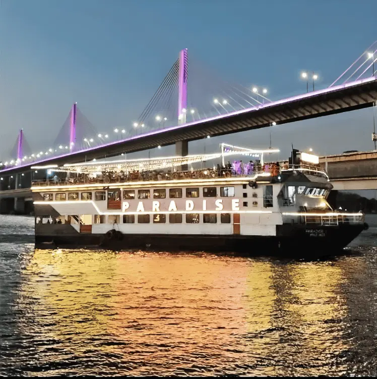 Paradise Dinner Cruise in Goa sailing along Mandovi River at dusk, illuminated boat by Goa Tourist Taxi
