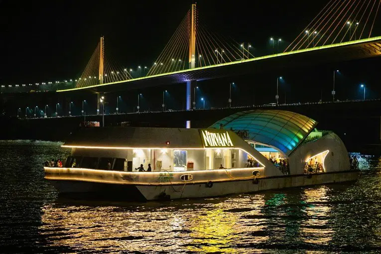 Nirvana Dinner Cruise in Goa sailing under twilight, elegantly lit boat by Goa Tourist Taxi